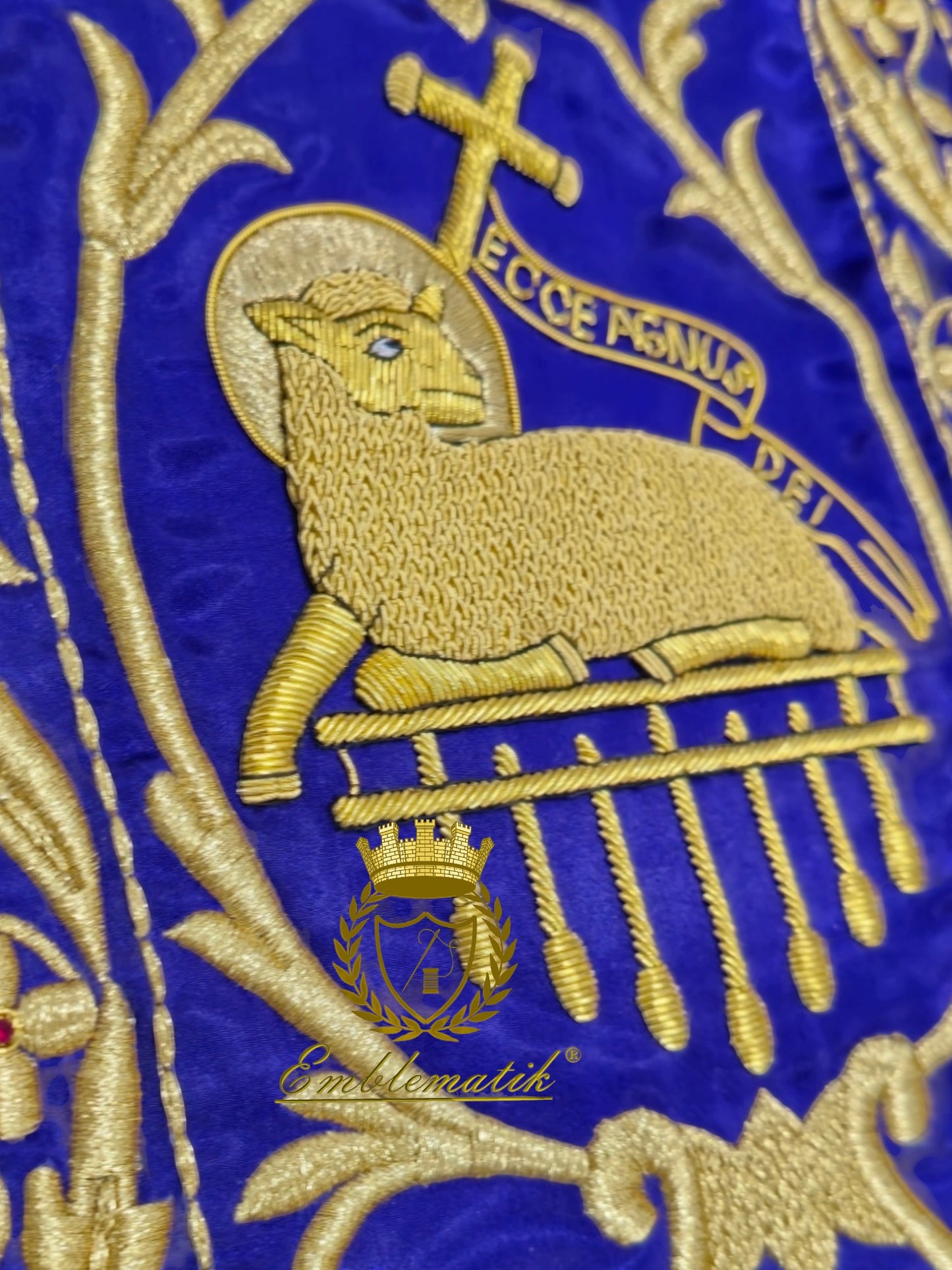 Emblematik by Pasamanerias y Bordados purple chasuble with gold metallic embroidery of Agnus Dei and cross.