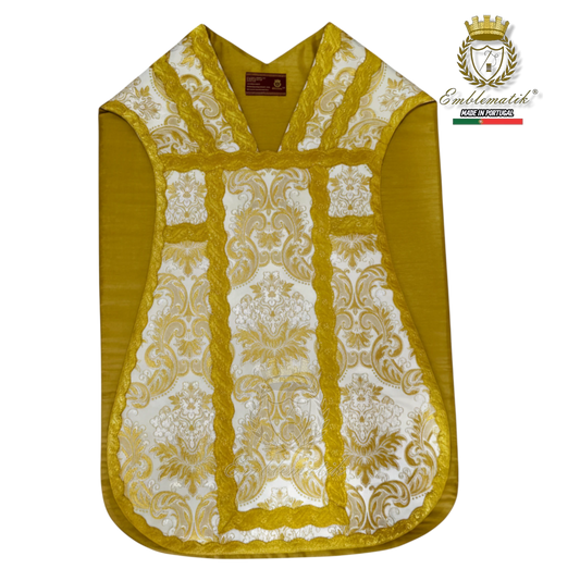 Emblematik by Pasamanerias y Bordados white and gold floral Roman chasuble with ornate trim.